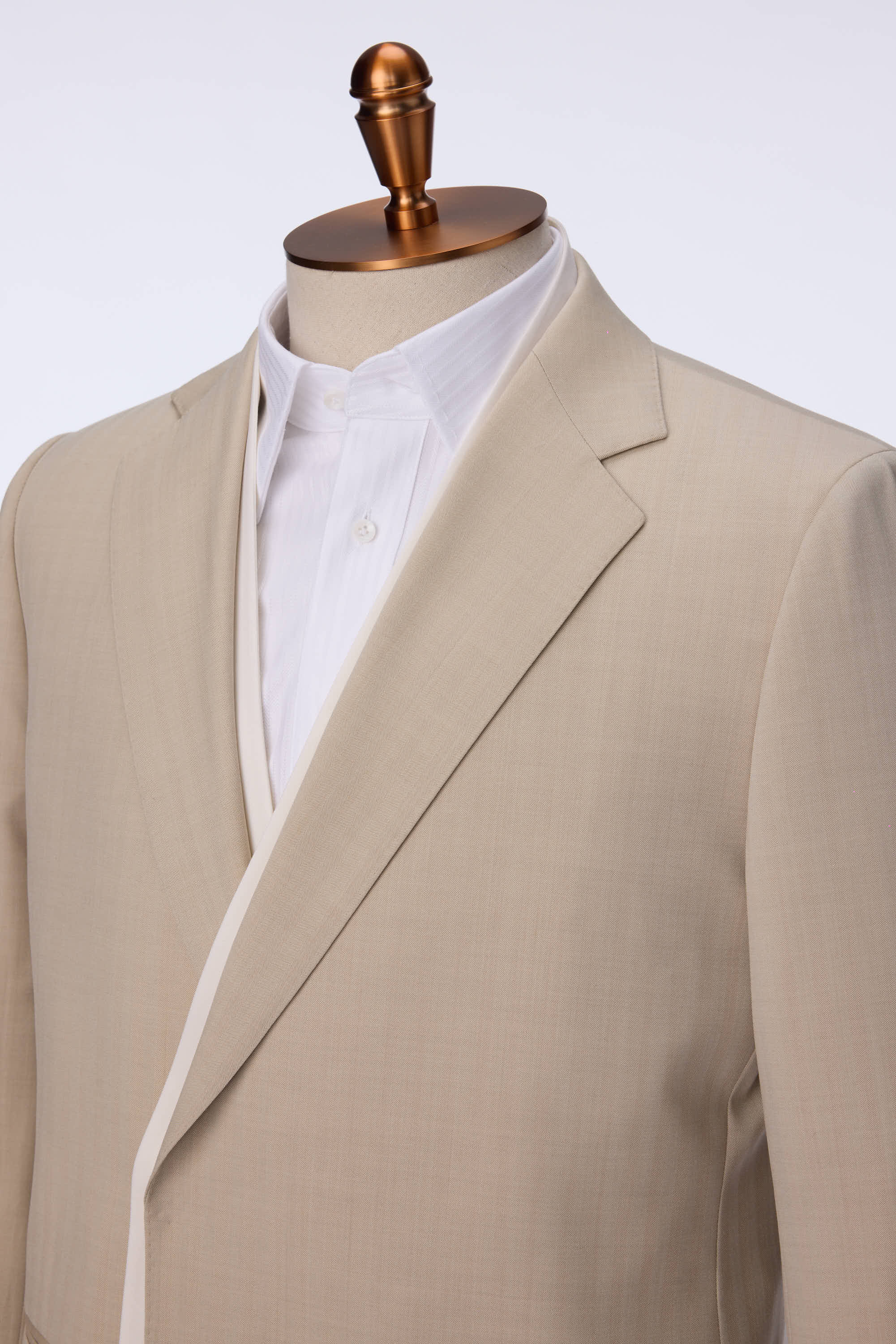 Crafted from 100% wool, this two-piece suit redefines business attire with a modern twist. The jacket features a double placket collar with a removable concept and an oblique placket design that enhances the silhouette with a fluid, cohesive shape. The subtle color block effect between white and khaki adds a refined softness, balancing contemporary style with traditional tailoring. Paired with matching trousers, this suit delivers a polished look for professional meetings, semi-formal events, or upscale soc