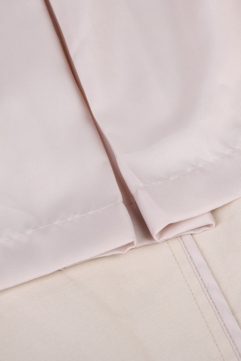 Close-up of a folded light pink fabric on a beige surface custom made suits for women