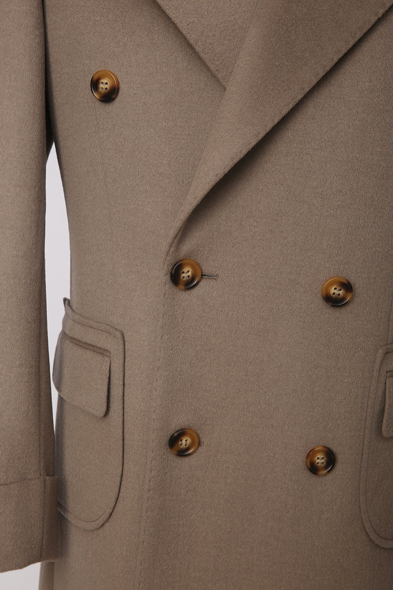 Close-up of a beige coat with double-breasted buttons on a light gray background