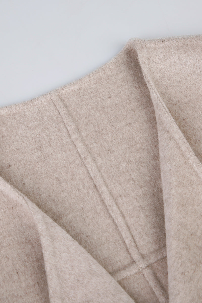 Close-up of beige fabric with a subtle texture on a light gray background
