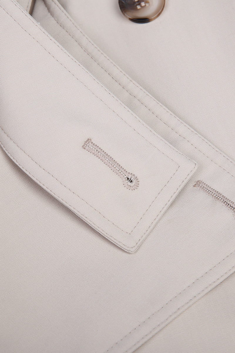 Close-up of a light gray fabric with a brand logo on a matching background custom made blazers