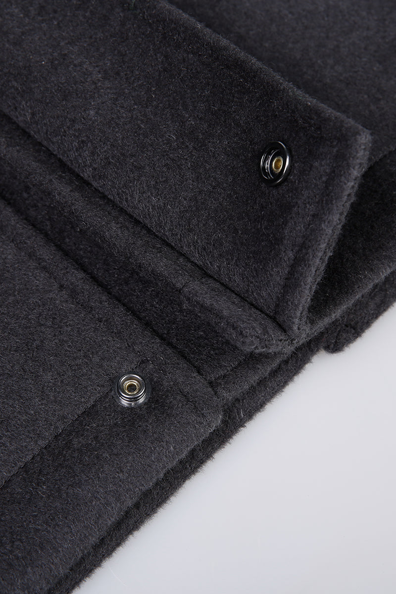 Close-up of a dark gray coat with buttons on a white background