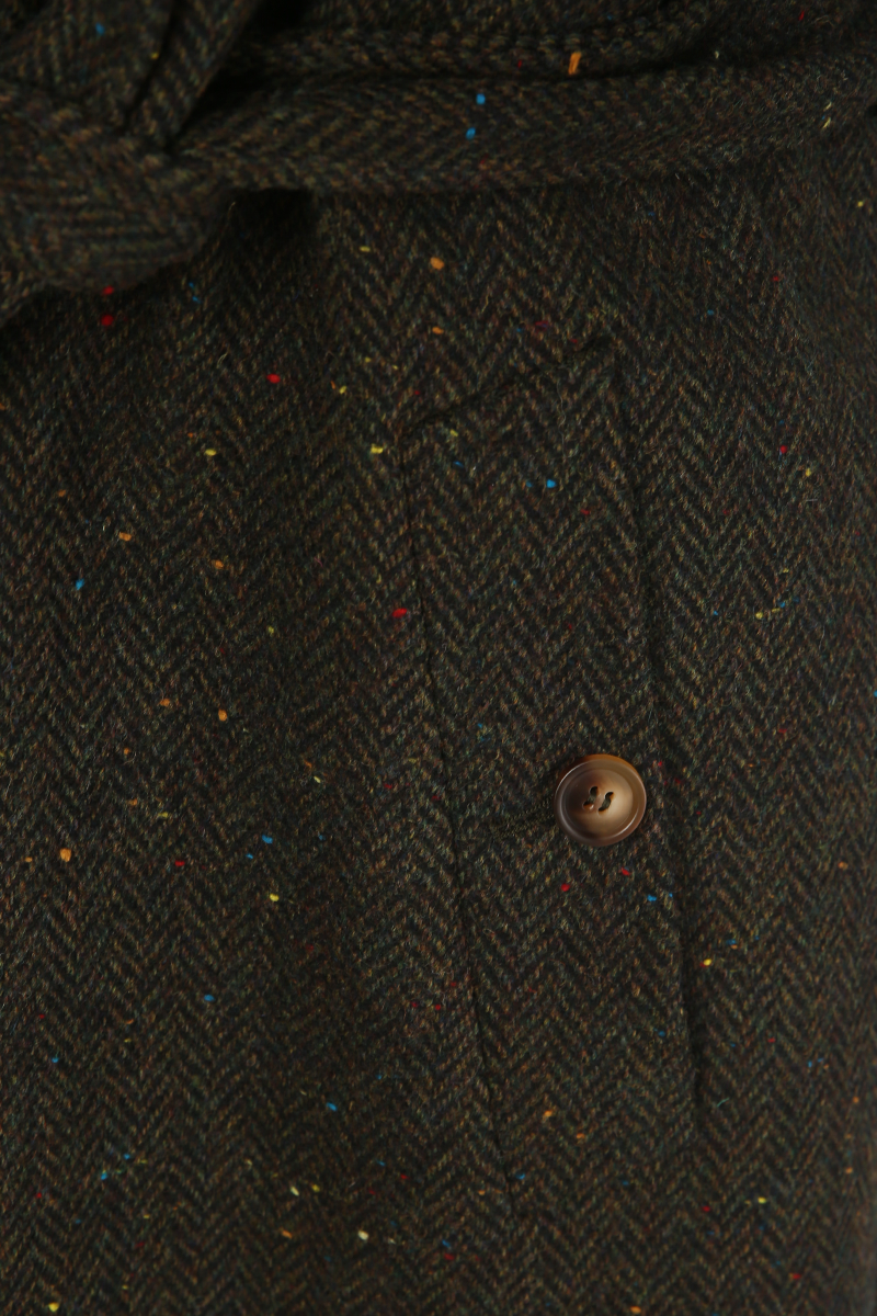 Close-up of a textured fabric with a button on a dark background