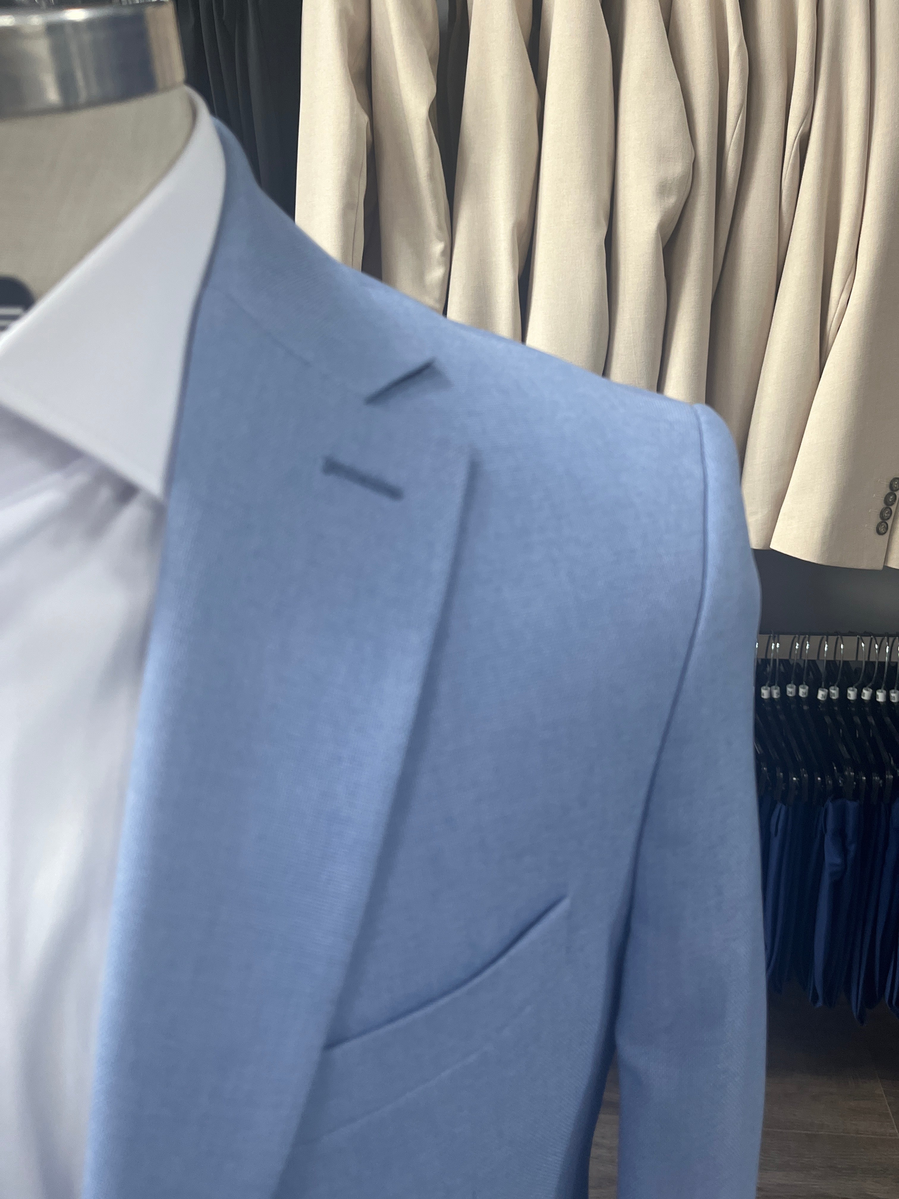 Close-up of a light blue suit jacket with pleats on a blurred background sport coats sale 