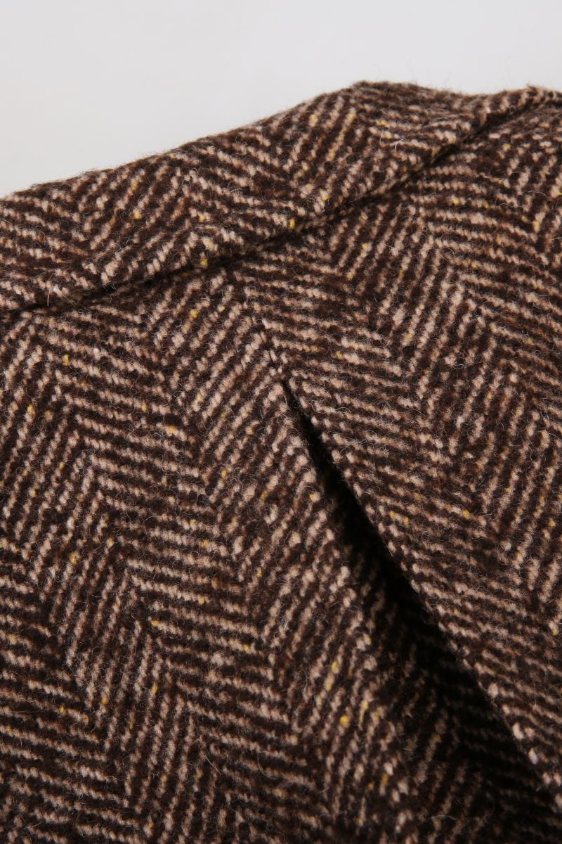 Close-up of brown herringbone fabric texture custom made tweed jackets 