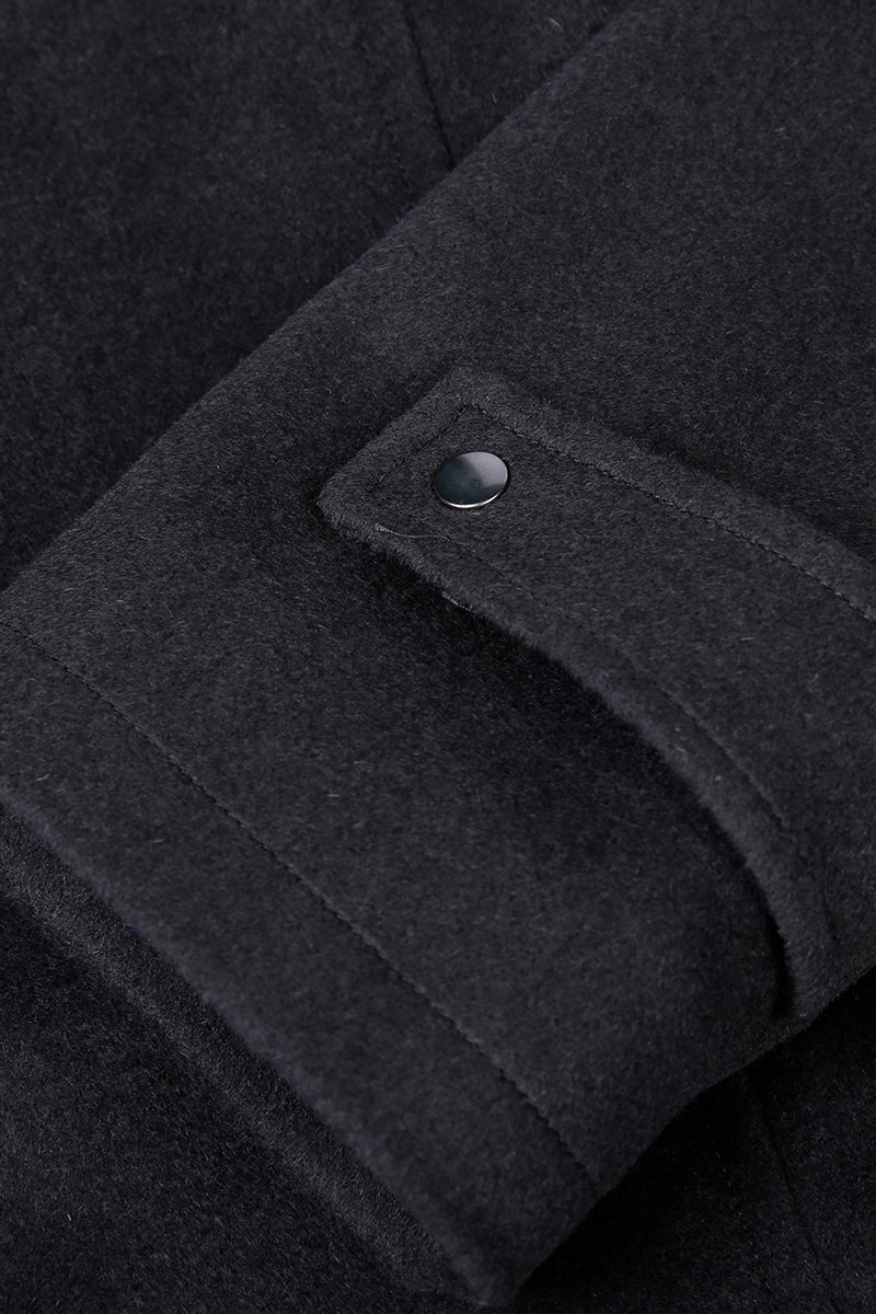 Close-up of a dark gray coat with a button detail
