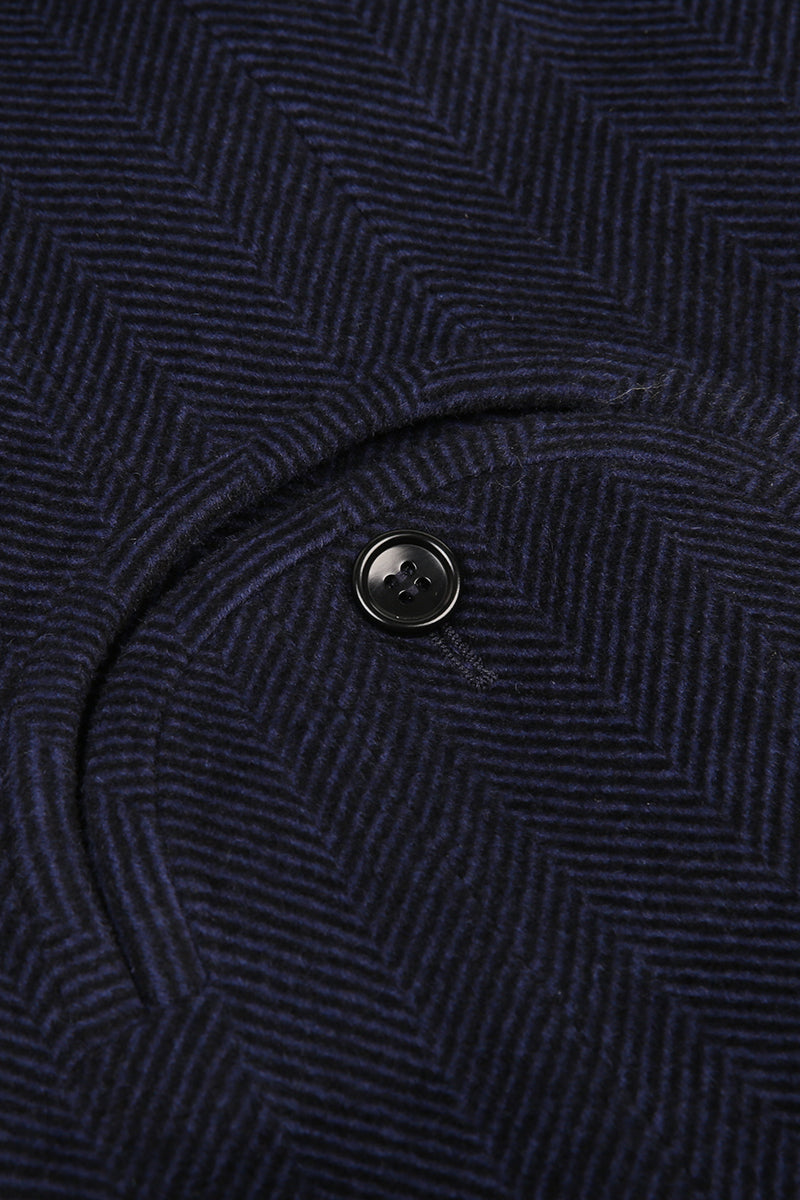 Close-up of a dark blue textured fabric with a button