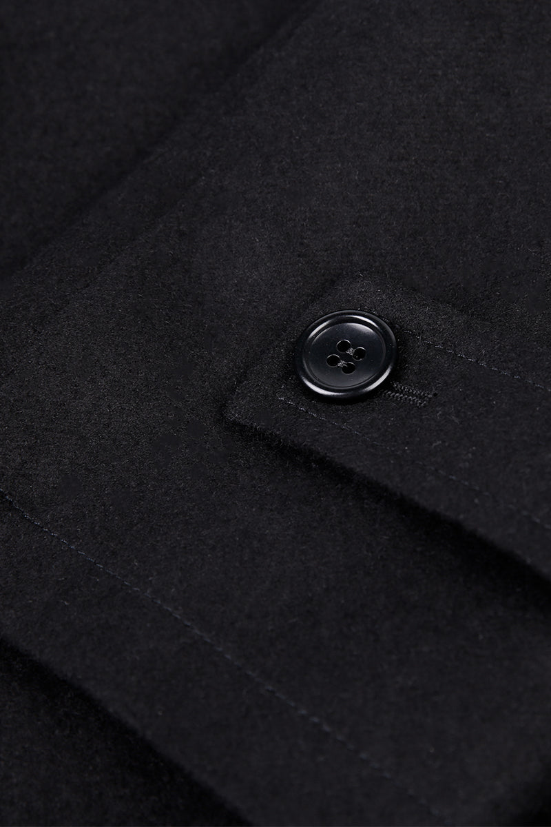Close-up of a black coat button on a dark background